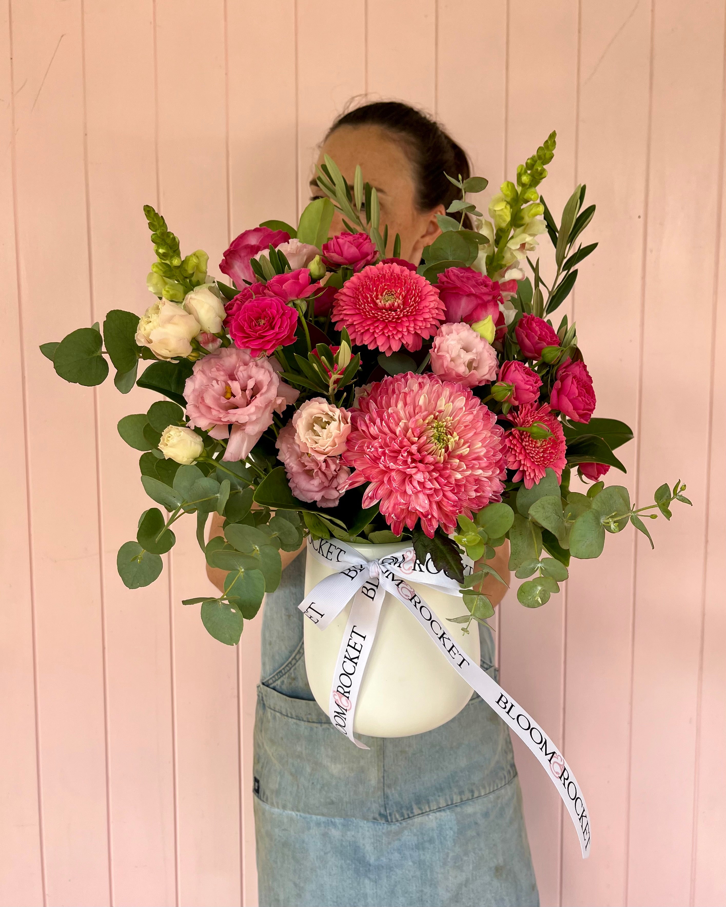 Arrangement of flowers with a variety of pink, red, and white flowers, arranged in a ceramic vase. Bloom and Rocket Florist. Brisbane Flower Delivery.