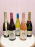 An assortment of bottled alcoholic beverages, including champagne and wine. Flowers and Wine delivery Brisbane. Bloom and Rocket Florist.
