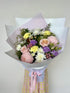 Bouquet of flowers wrapped in paper with a pink ribbon. Mother’s Day flowers. Brisbane Flower Delivery.