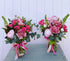 Two floral arrangements with vibrant pink flowers and green foliage, tied with pink.ribbons, displayed on a table. Dazzle me twice. Bloom and rocket florist. Brisbane same day flower delivery. 
